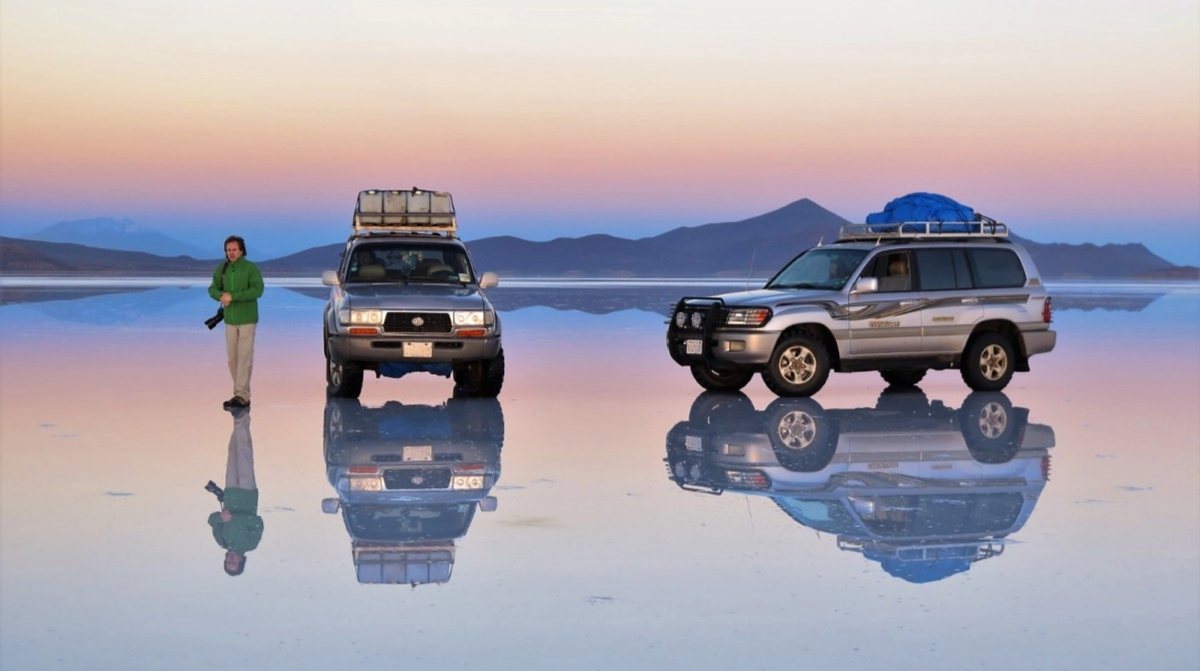 Toyota Land Cruiser reflejadas en el espejo del salar al atardecer